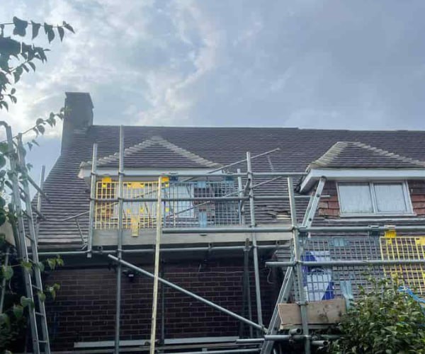 This is a photo of a roof with two dormers that is having some damaged tiles replaced. Works carried out by SC Roofing Olney